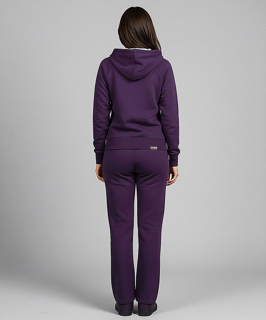 Person wearing a purple tracksuit on a gray background